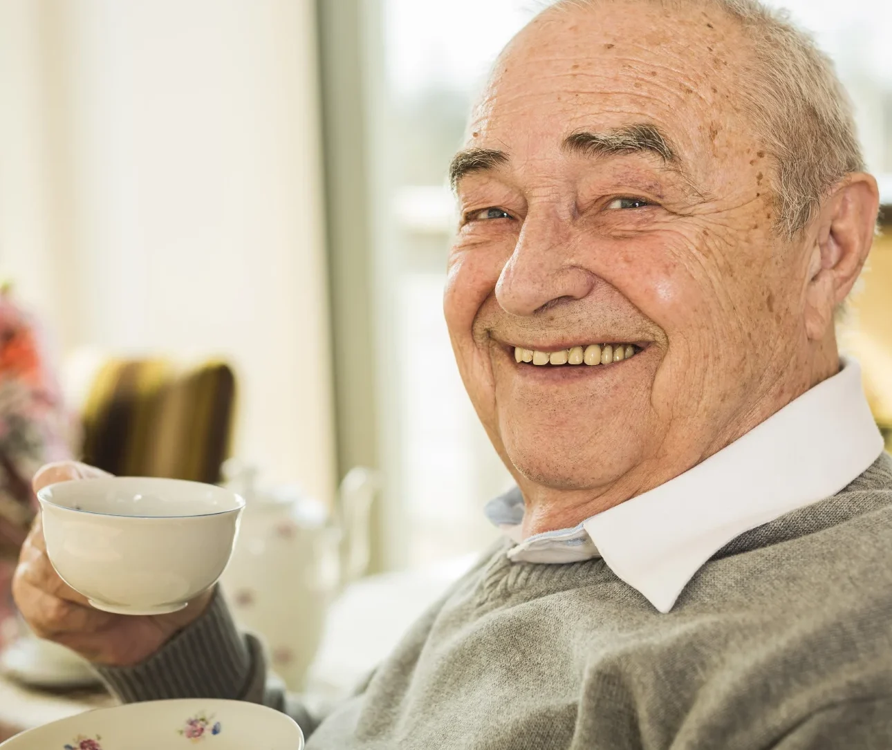 Happy elderly man with cup of coffee
